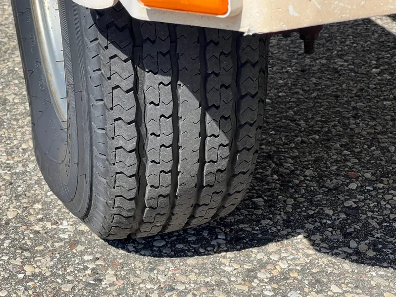 Slide: The Image of Close-up of a 2001 Alumacraft Trophy 175 trailer tire on asphalt. - 8
