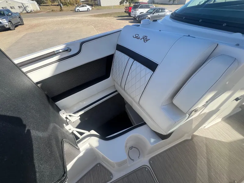 Slide: The Image of 2018 Sea Ray 280 SLX boat interior with white seating and storage compartment. - 14