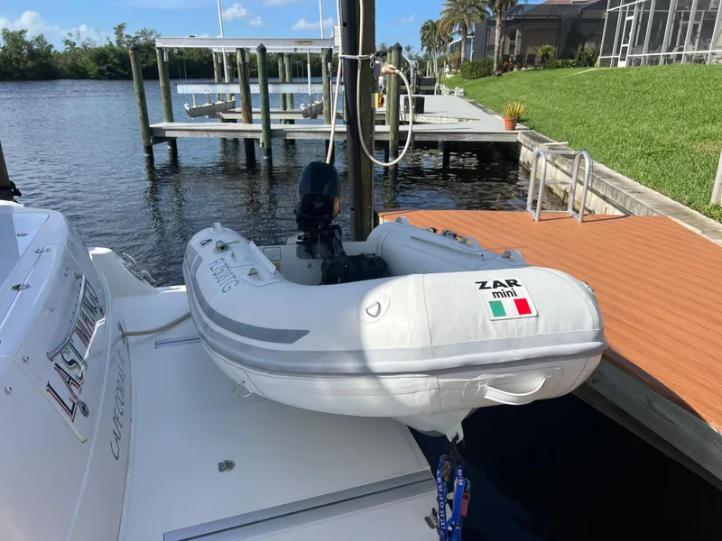 Slide: The Image of 2007 Sea Ray 52 Sedan Bridge with Zar Mini inflatable boat docked by a waterfront. - 11