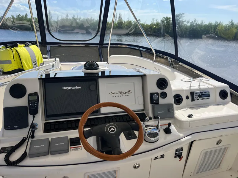 Slide: The Image of 2007 Sea Ray 52 Sedan Bridge helm with navigation equipment and wooden steering wheel. - 25