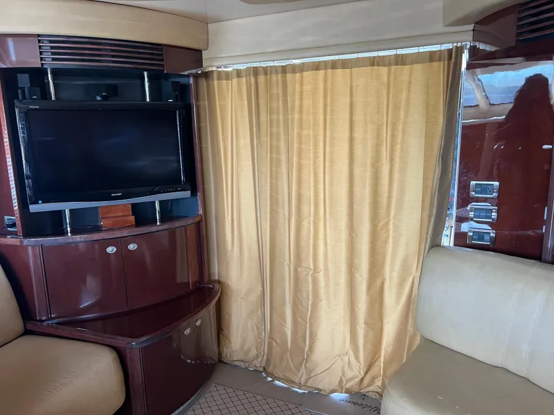 Slide: The Image of Interior of 2007 Sea Ray 52 Sedan Bridge with TV and beige curtains. - 32