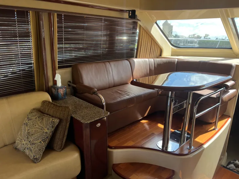 Slide: The Image of Luxurious interior of 2007 Sea Ray 52 Sedan Bridge yacht with leather seating and wooden table. - 36