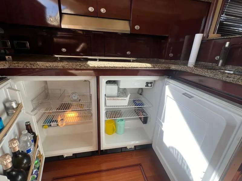 Slide: The Image of 2007 Sea Ray 52 Sedan Bridge kitchen with open fridge and wooden flooring. - 40