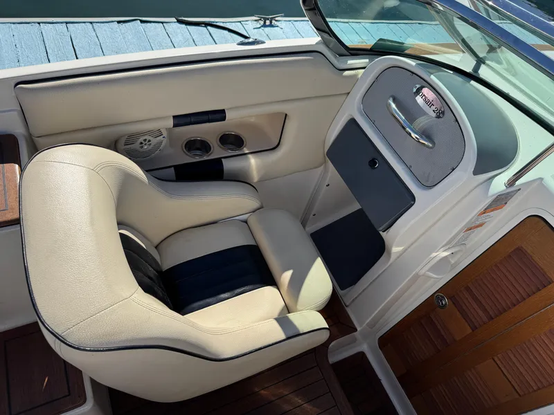 Slide: The Image of 2005 Chris-Craft Corsair 28 boat interior with beige seating and wooden accents. - 14