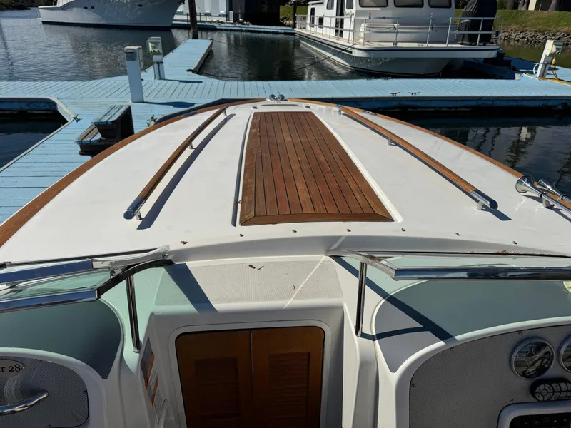 Slide: The Image of 2005 Chris-Craft Corsair 28 boat docked, featuring sleek design and wooden deck accents. - 15