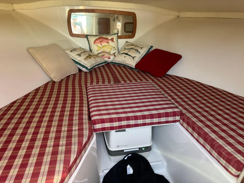 Slide: The Image of 2005 Chris-Craft Corsair 28 cabin with red plaid cushions and decorative pillows. - 16