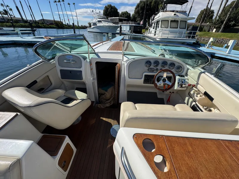 Slide: The Image of 2005 Chris-Craft Corsair 28 boat interior with steering wheel and seating, docked at marina. - 21