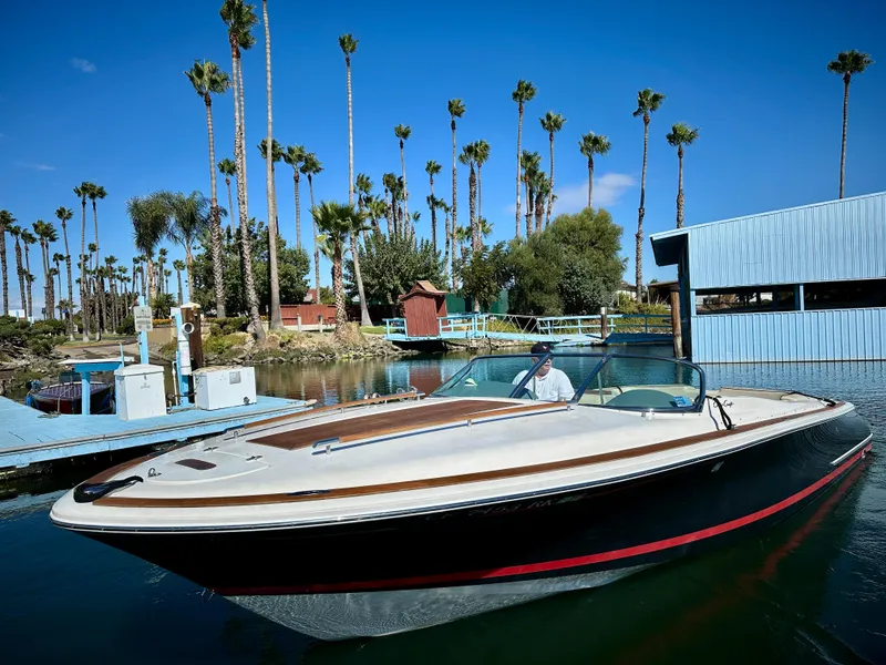 Slide: The Image of 2005 Chris-Craft Corsair 28 boat on a sunny day, surrounded by palm trees. - 3