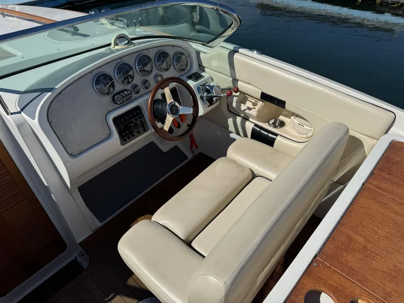 Slide: The Image of 2005 Chris-Craft Corsair 28 boat interior with beige seating and classic dashboard. - 7