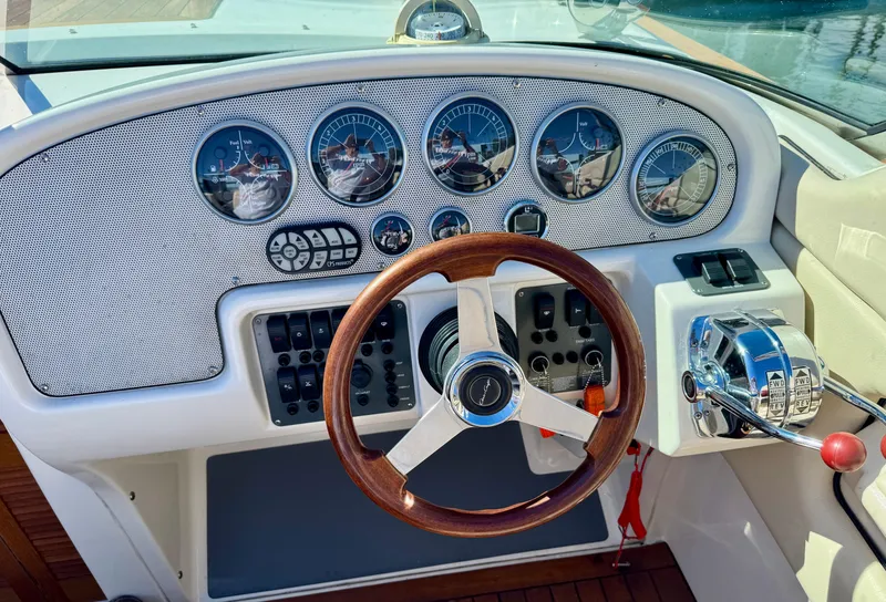 Slide: The Image of 2005 Chris-Craft Corsair 28 dashboard with wooden steering wheel and control panel. - 8