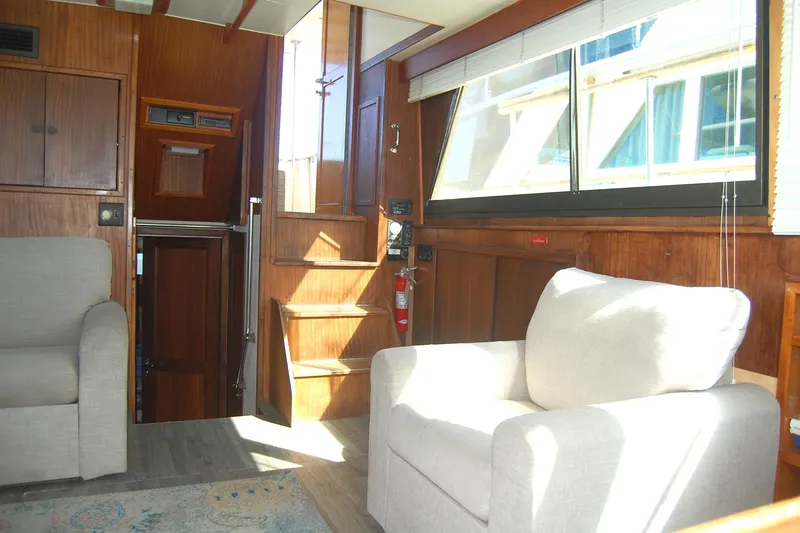 Slide: The Image of Interior of 1981 Hatteras 48 Cockpit MY yacht with wooden paneling and beige seating. - 13