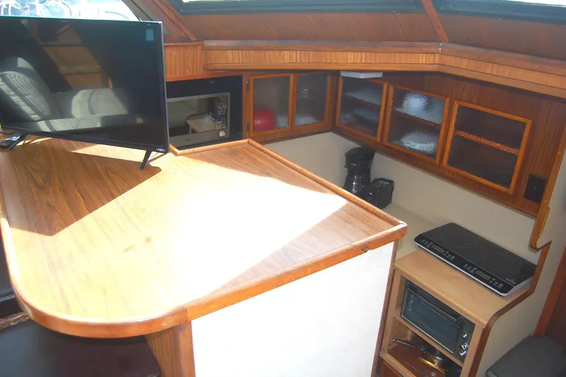 Slide: The Image of Interior of 1981 Hatteras 48 Cockpit MY yacht with wooden cabinetry and modern appliances. - 15