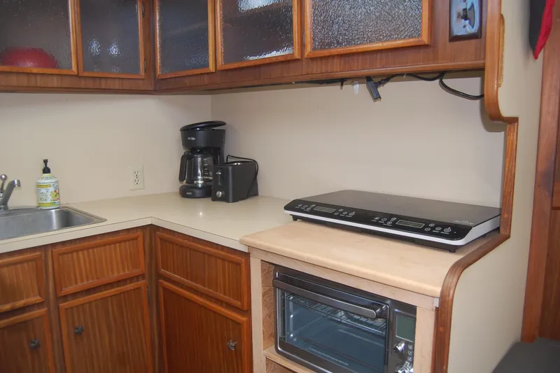 Slide: The Image of Kitchen area of 1981 Hatteras 48 Cockpit MY with appliances and wooden cabinets. - 18