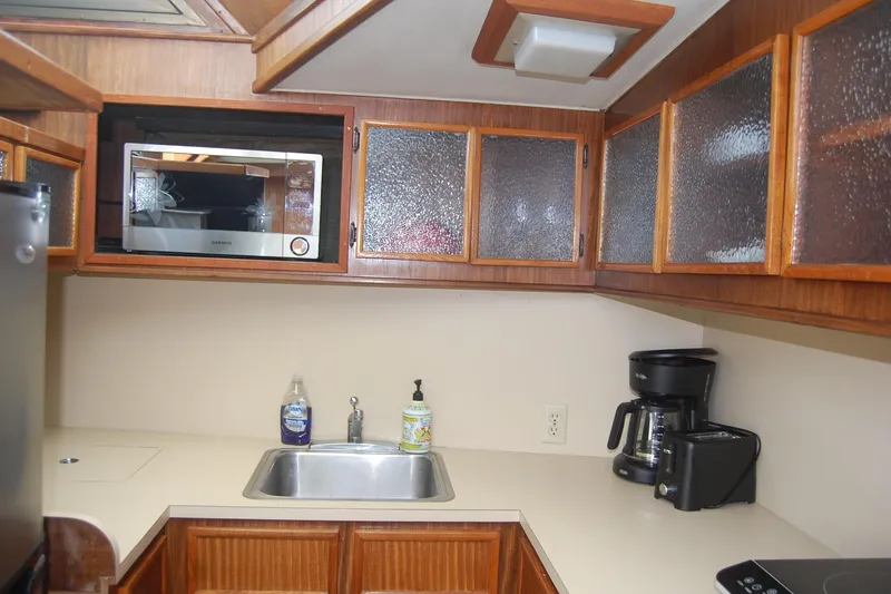 Slide: The Image of 1981 Hatteras 48 Cockpit MY kitchen with microwave, sink, and coffee maker. - 19