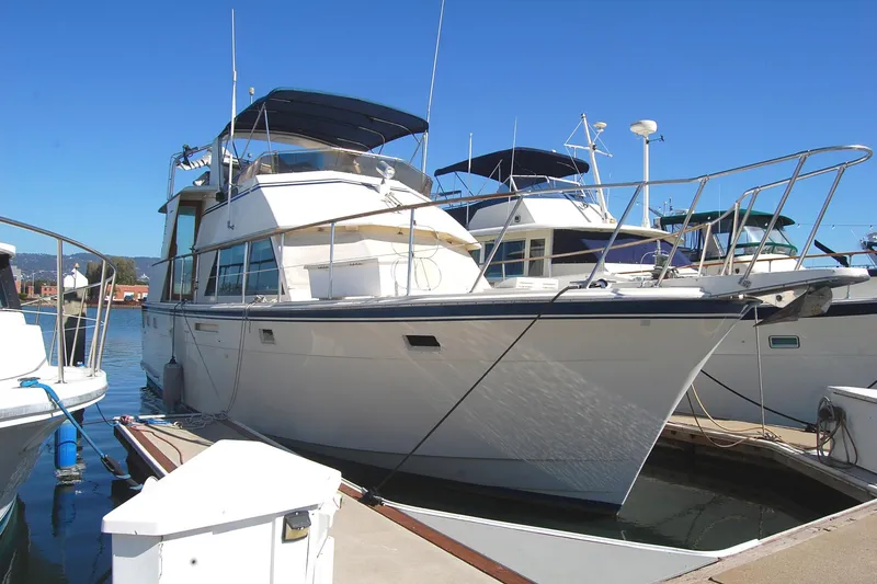 Slide: The Image of 1981 Hatteras 48 Cockpit MY yacht docked at marina under clear blue sky. - 2