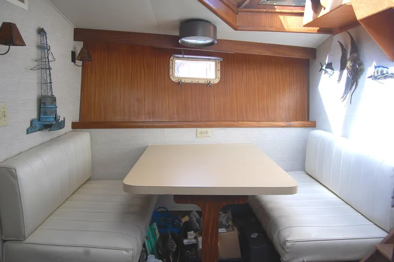 Slide: The Image of 1981 Hatteras 48 Cockpit MY interior with dining area, wood paneling, and white seating. - 21
