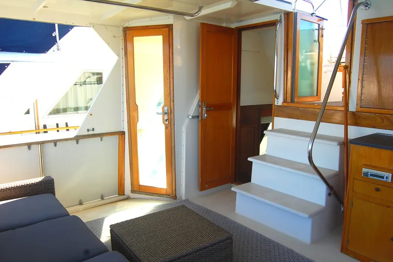 Slide: The Image of 1981 Hatteras 48 Cockpit MY interior with wooden doors, stairs, and seating area. - 33