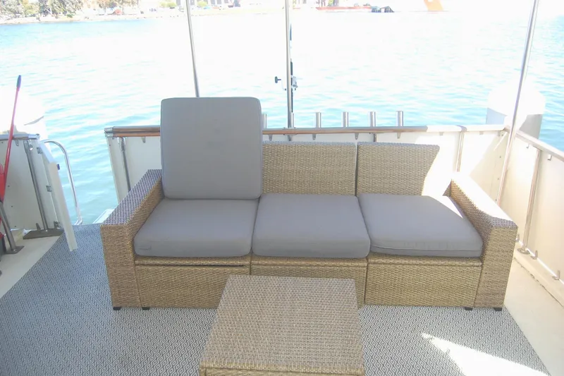 Slide: The Image of Wicker seating on 1981 Hatteras 48 Cockpit MY yacht, overlooking serene water. - 34
