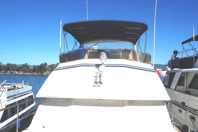 Slide: The Image of 1981 Hatteras 48 Cockpit MY yacht docked under clear blue sky. - 46