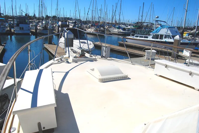 Slide: The Image of 1981 Hatteras 48 Cockpit MY yacht docked in a marina, surrounded by sailboats. - 47