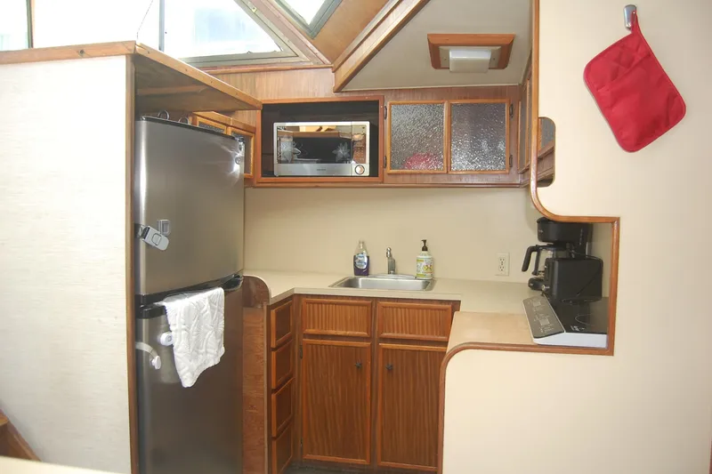 Slide: The Image of Compact kitchen in 1981 Hatteras 48 Cockpit MY yacht with fridge, microwave, and wooden cabinets. - 5