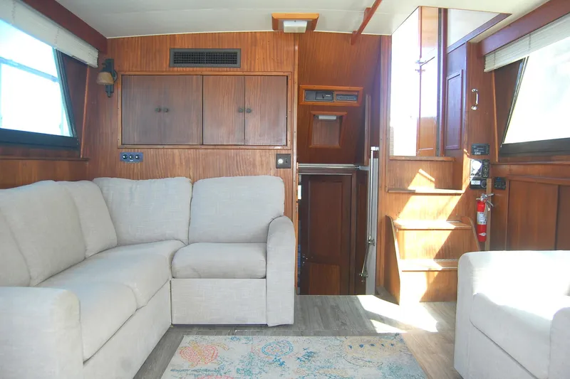 Slide: The Image of Interior of 1981 Hatteras 48 Cockpit MY with beige sofa and wooden cabinetry. - 11