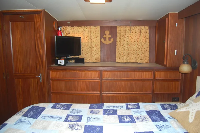 Slide: The Image of 1981 Hatteras 48 Cockpit MY cabin interior with wood paneling, TV, and nautical decor. - 22