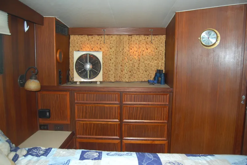 Slide: The Image of 1981 Hatteras 48 Cockpit MY interior with wood paneling, fan, and storage drawers. - 23