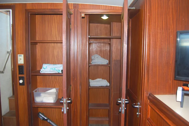 Slide: The Image of Interior of 1981 Hatteras 48 Cockpit MY with open wooden cabinets and shelves. - 25