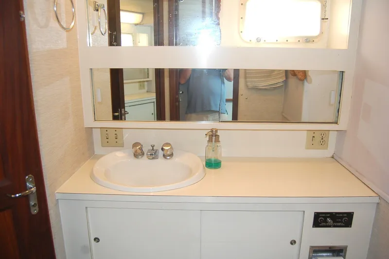 Slide: The Image of 1981 Hatteras 48 Cockpit MY bathroom with sink, mirror, and soap dispenser. - 26