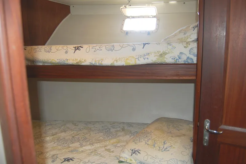 Slide: The Image of 1981 Hatteras 48 Cockpit MY cabin with bunk beds and floral bedding. - 31