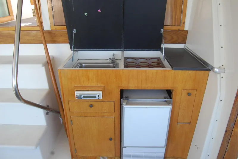 Slide: The Image of Compact kitchen area on 1981 Hatteras 48 Cockpit MY yacht with sink and stove. - 35