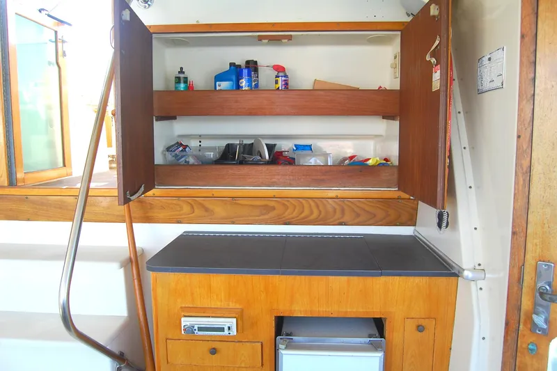Slide: The Image of 1981 Hatteras 48 Cockpit MY interior with wooden cabinets and storage shelves. - 36
