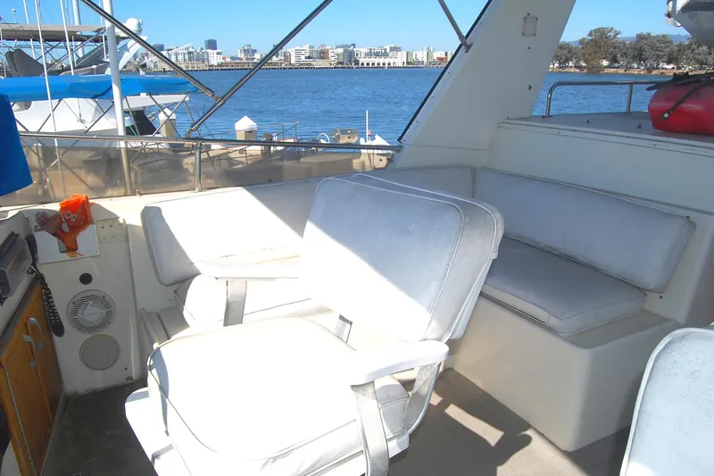 Slide: The Image of 1981 Hatteras 48 Cockpit MY yacht interior with white seating and waterfront view. - 38
