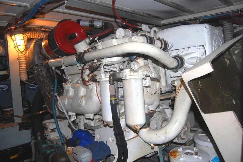 Slide: The Image of Engine room of 1981 Hatteras 48 Cockpit MY, showcasing mechanical components and piping. - 51