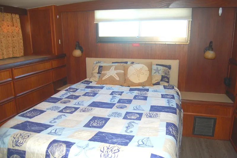 Slide: The Image of Cozy bedroom in 1981 Hatteras 48 Cockpit MY with nautical-themed bedding. - 6