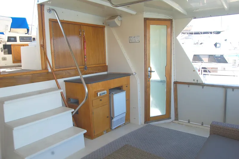 Slide: The Image of 1981 Hatteras 48 Cockpit MY interior with stairs, wooden cabinetry, and glass door. - 8