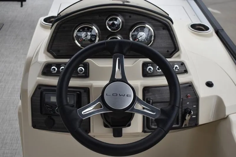 Slide: The Image of 2023 Lowe SF212 Walk-Through boat dashboard with steering wheel and gauges. - 25