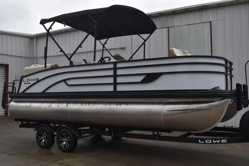 Slide: The Image of 2023 Lowe SF212 Walk-Through pontoon boat on trailer, parked outdoors. - 3