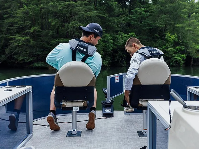 Slide: The Image of Two people seated on a 2023 Lowe SF212 Walk-Through boat, enjoying a serene lake view. - 36