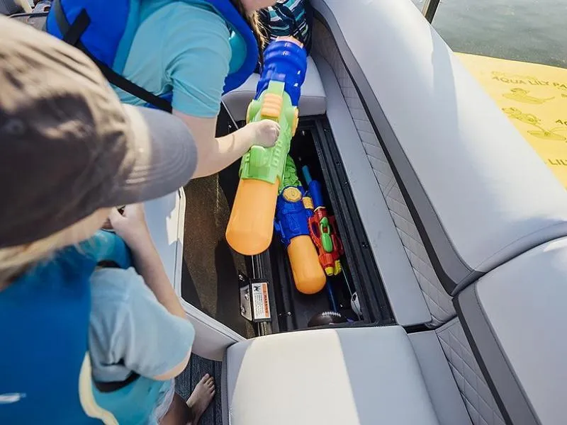 Slide: The Image of Children retrieving water guns from storage on a 2023 Lowe SF212 Walk-Through boat. - 37