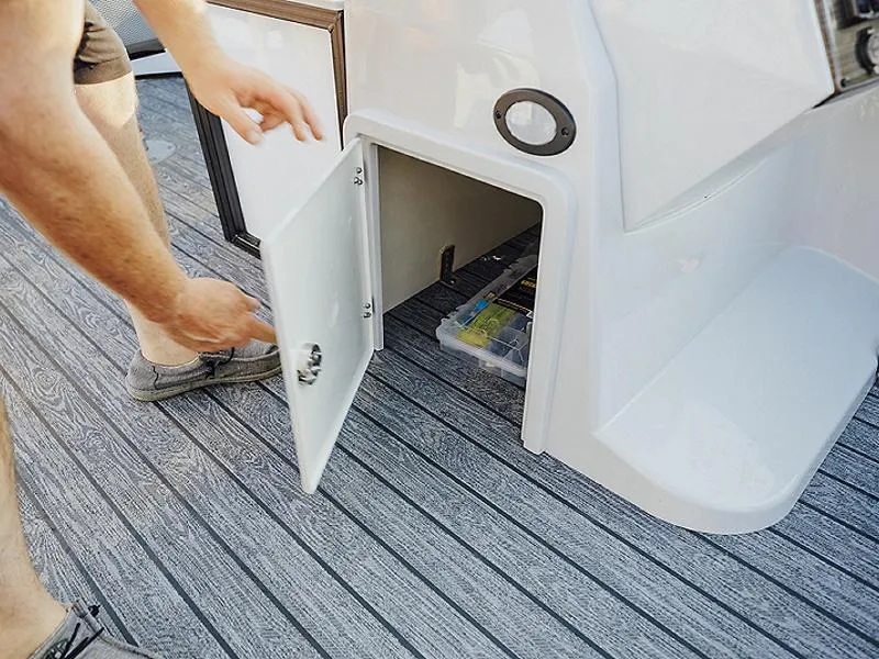 Slide: The Image of 2023 Lowe SF212 Walk-Through boat storage compartment with person accessing interior. - 38