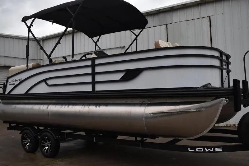 Slide: The Image of 2023 Lowe SF212 Walk-Through pontoon boat on trailer, featuring a sleek design and canopy. - 5