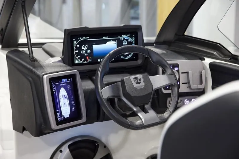 Slide: The Image of 2021 Malibu 21 MLX boat dashboard with modern digital displays and steering wheel. - 10