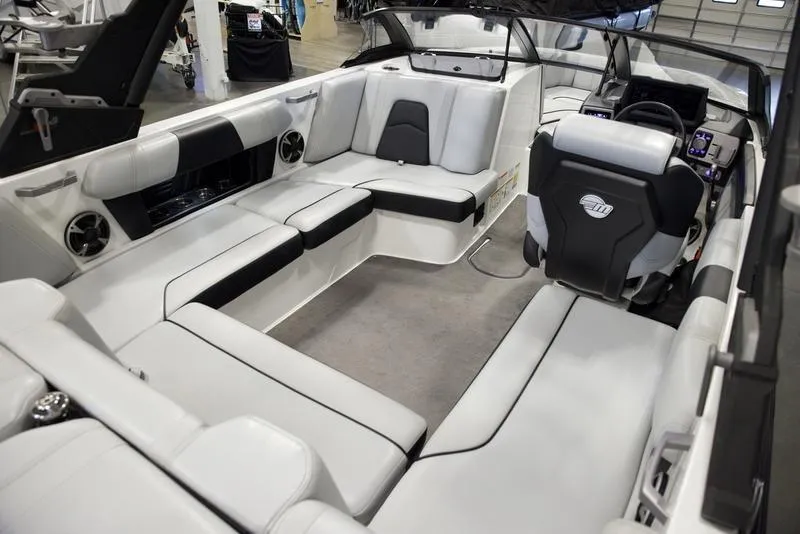 Slide: The Image of 2021 Malibu 21 MLX boat interior with luxurious seating and modern dashboard. - 13