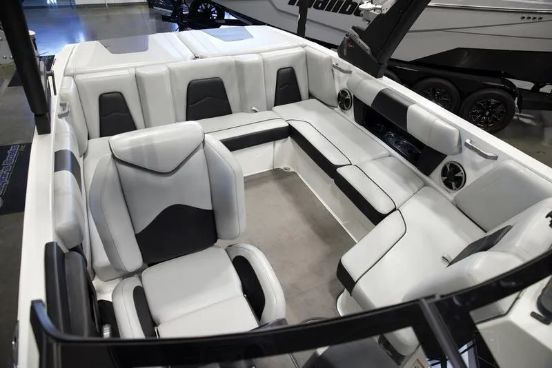 Slide: The Image of 2021 Malibu 21 MLX boat interior with white and black seating, modern design. - 15