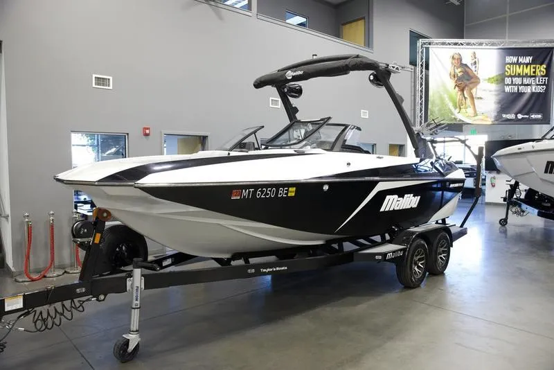 Slide: The Image of 2021 Malibu 21 MLX boat on trailer in showroom. - 2