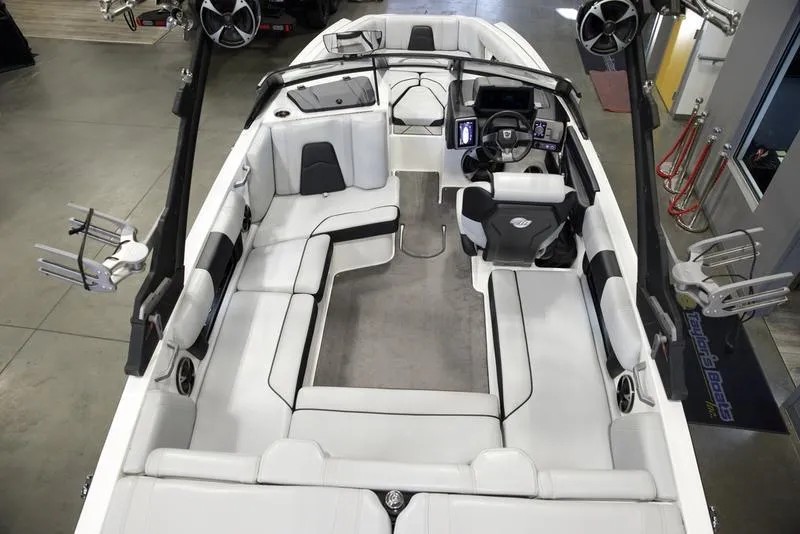 Slide: The Image of 2021 Malibu 21 MLX boat interior with spacious seating and modern dashboard. - 7