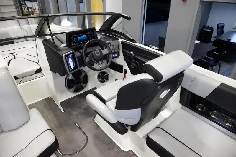Slide: The Image of 2021 Malibu 21 MLX boat interior with modern dashboard and seating. - 9