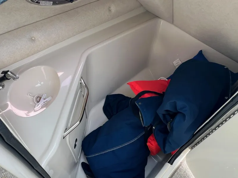 Slide: The Image of 2009 Sea Ray 240 Sundeck interior storage with life jackets and sink. - 13